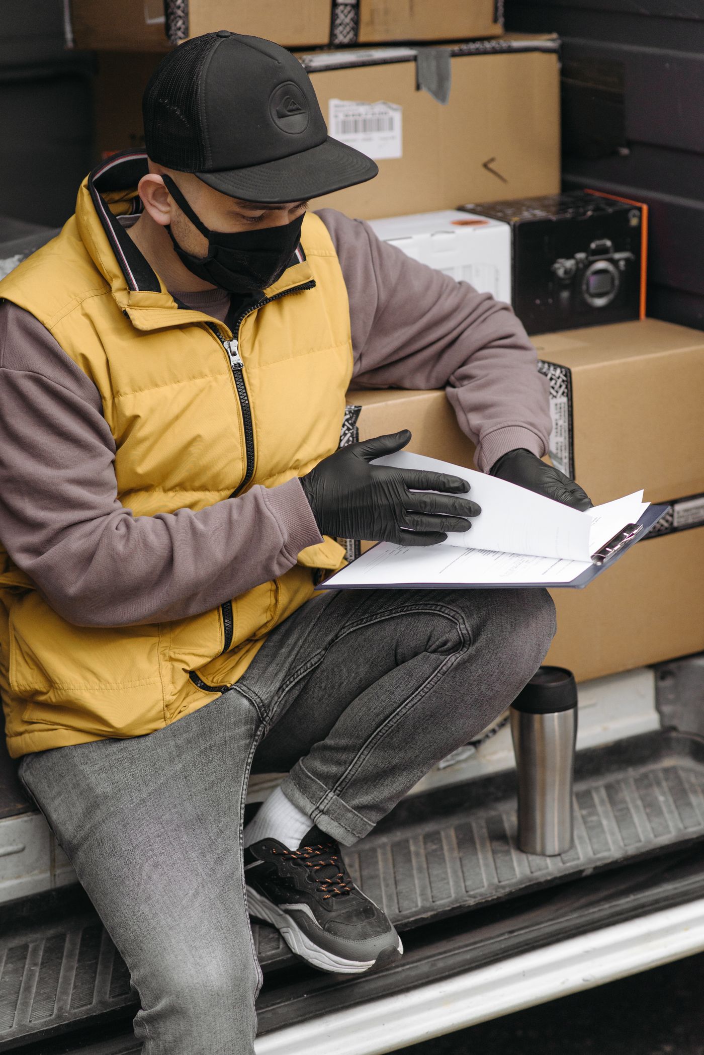 Courier checking shipping documents beside a delivery van