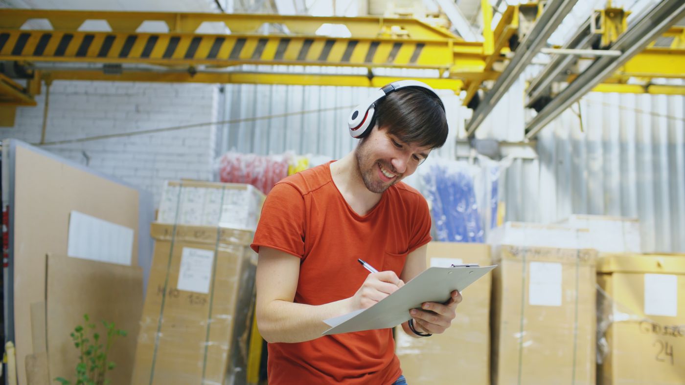 Warehouse worker recording inventory on a clipboard