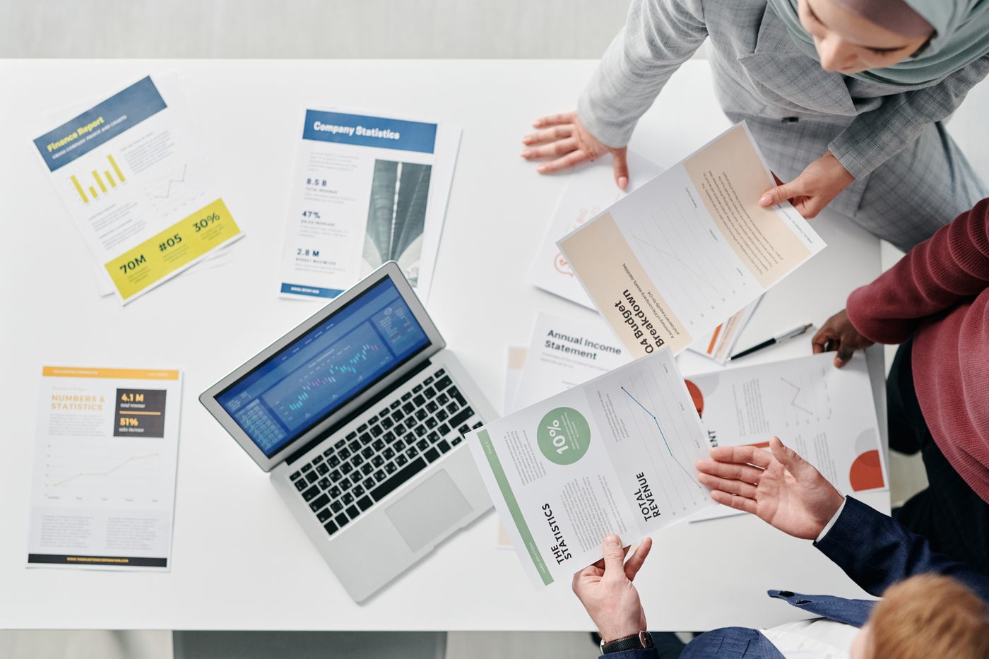 Overhead view of a planning meeting with documents and a laptop
